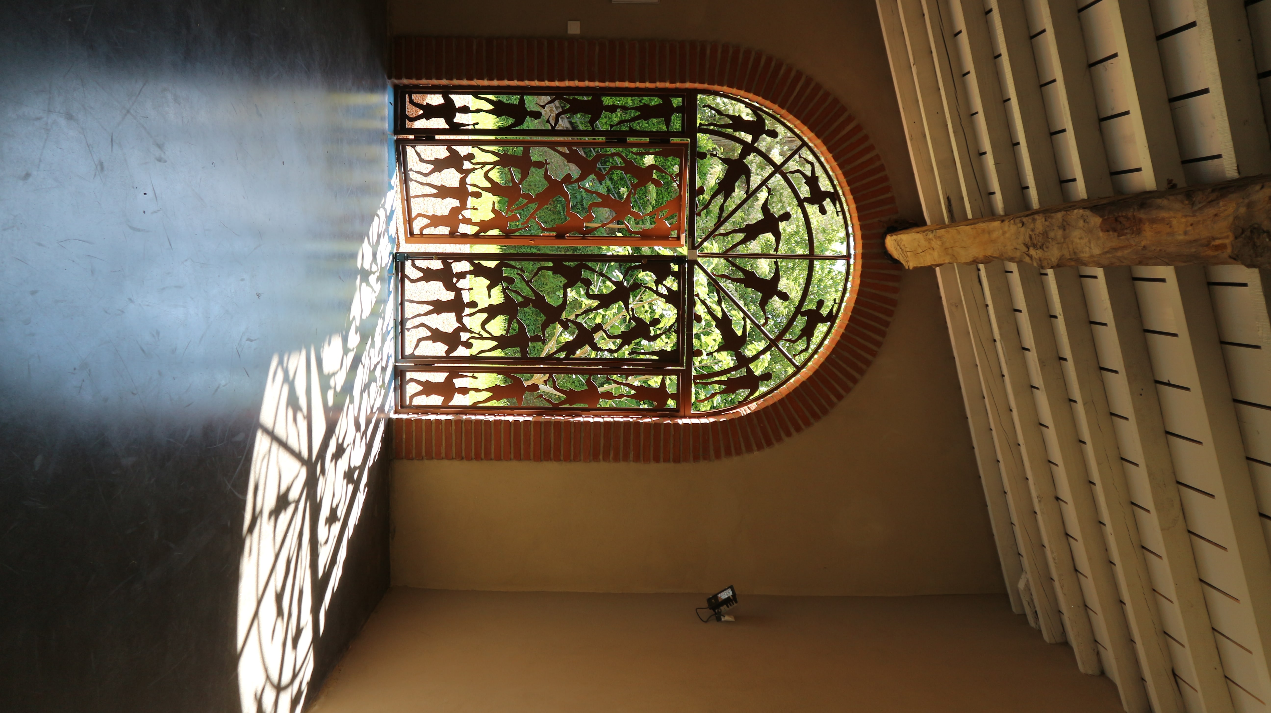 Verrière en vitrail dessinant des jeux d'ombre et de lumière sur un mur