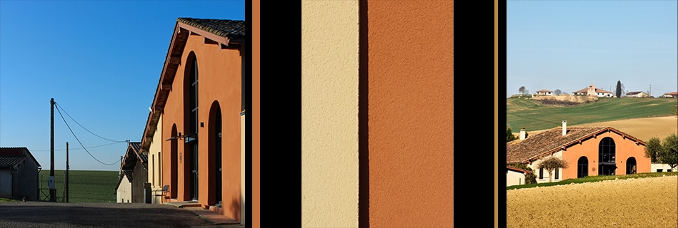 Façade principale ocre de la maison rénovée avec ses arcades, allée bordant l'exploitation et maison landaise sur les collines du Gers