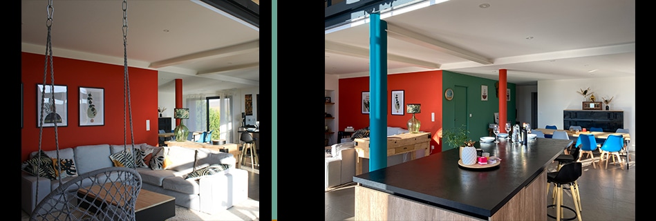 Grande pièce à vivre : fauteuil suspendu, mur corail, cuisine ouverte sur îlot noir et poteaux colorés turquoise et rouge