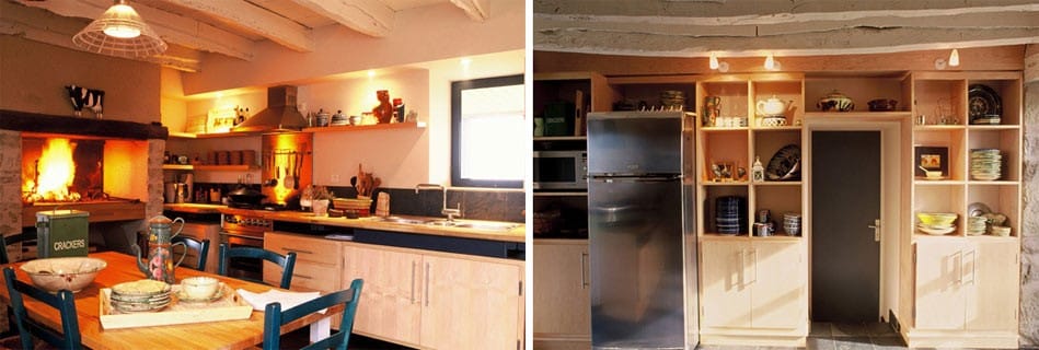 Cuisine familiale : cheminée en pierre, plan de travail bois sur piètement acier et rangements toute hauteur en bois clair autour de la porte