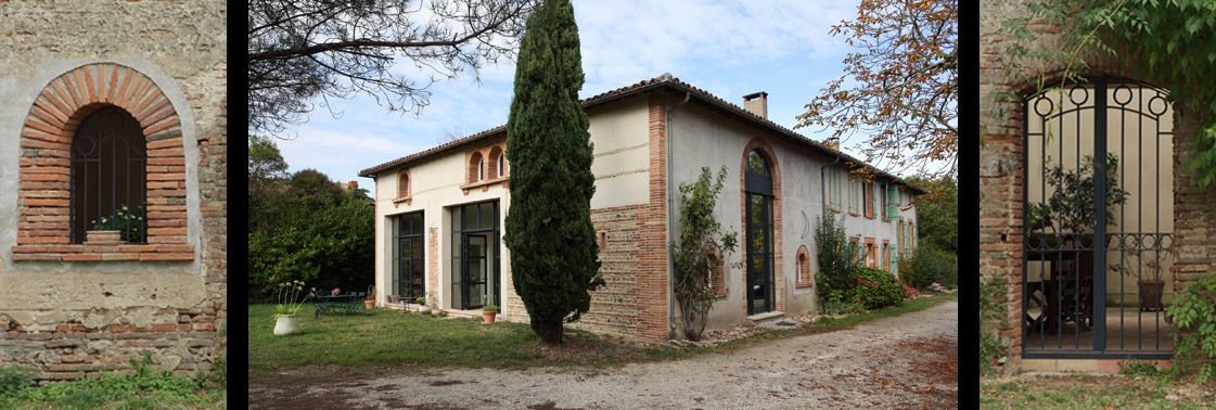 Détail d'une fenêtre cintrée en brique, la longue ferme vue depuis l'allée de gravier avec cyprès et cheminée, et portail vitré en acier sous une arche