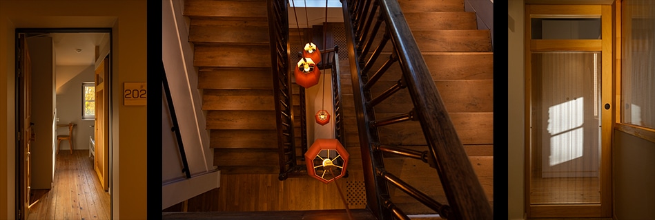 Enfilade d'une chambre numérotée 202, et cage d'escalier en bois animée de lanternes rouges suspendues