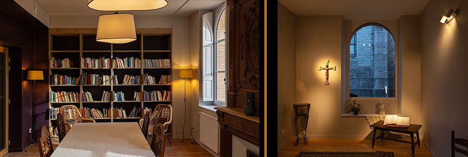 Bibliothèque-salle à manger aux rayonnages garnis et grande table sous suspension, et coin de prière au crucifix devant une fenêtre cintrée