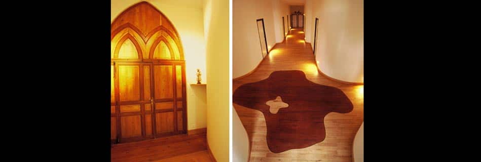 Placard-oratoire en bois à arc gothique éclairé, et couloir courbe au parquet incrusté d'un motif organique et d'une petite croix