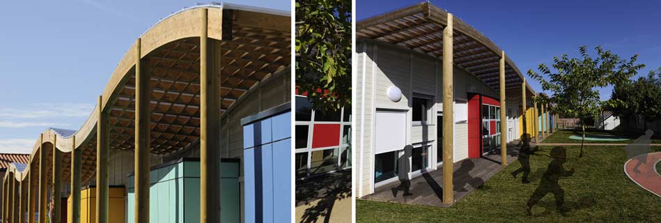 Toiture ondulée en lamellé-collé sur poteaux bois, préau et façades colorées ouverts sur le jardin où jouent des enfants
