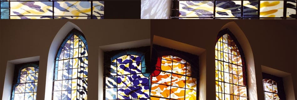 Vitraux contemporains aux couleurs vives, bleu, jaune et orange, dans les baies gothiques