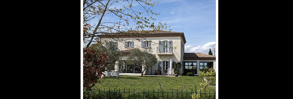 La maison de Pujaudran vue du jardin, avec sa nouvelle véranda vitrée greffée sous la terrasse couverte en façade ouest